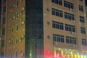 Un immeuble à plusieurs étages doté d’une façade incurvée, de nombreuses fenêtres et de climatiseurs.
