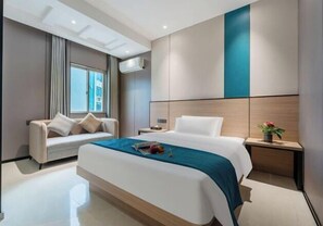 Relax in a stylish room with a large bed, sofa, and city view.