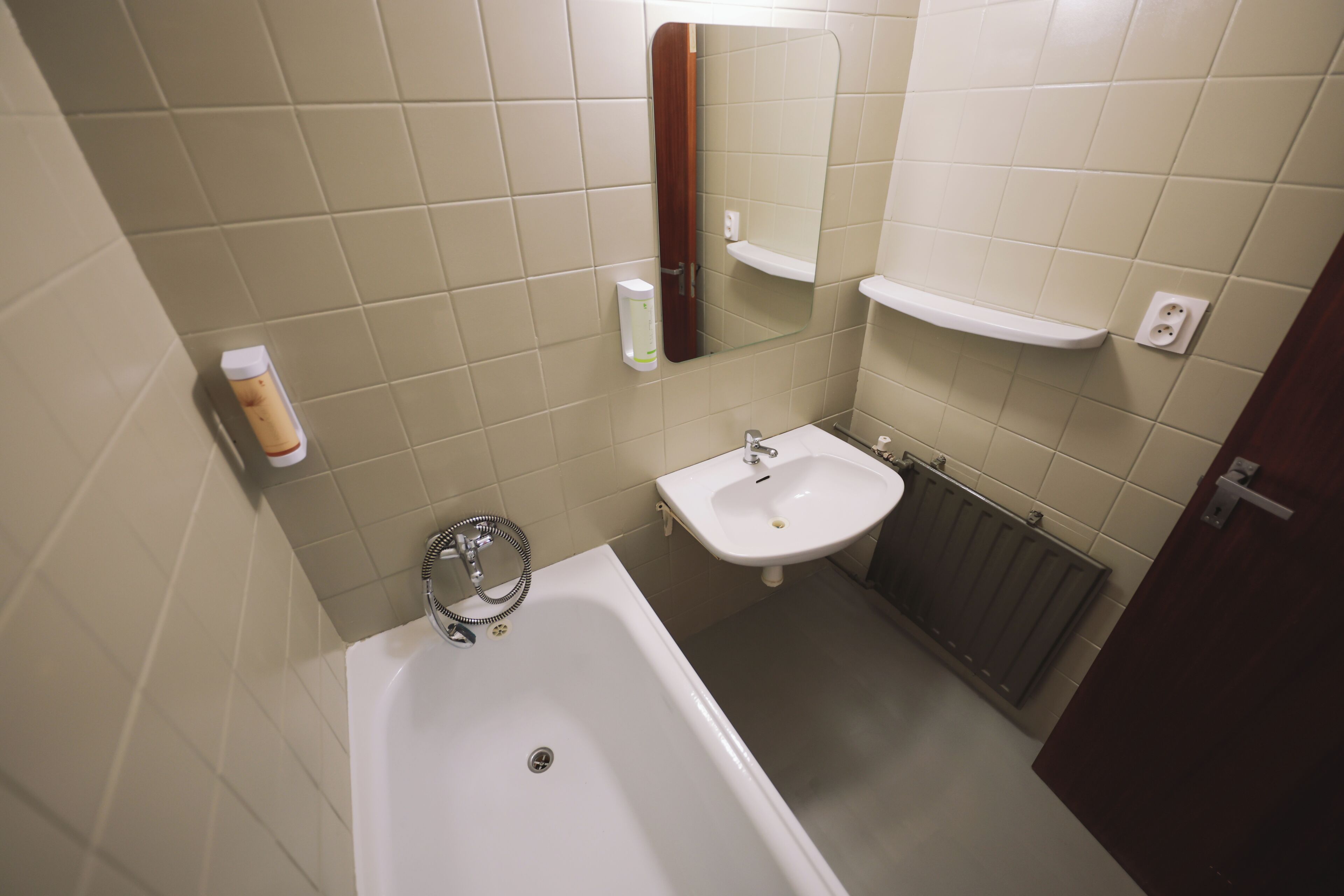 Un baño con bañera, lavabo y espejo.