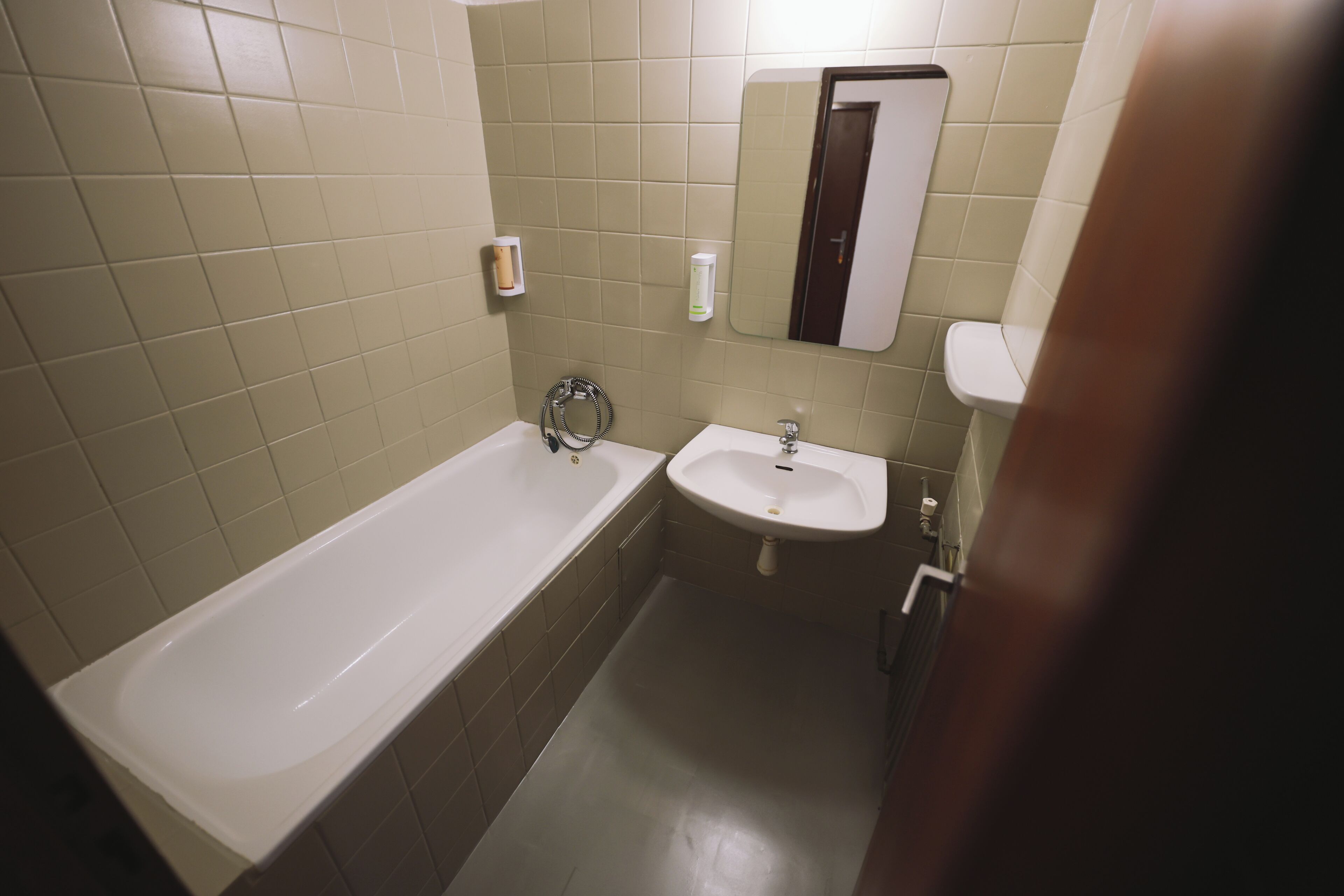 A bathroom with a bathtub, a sink, and a mirror.