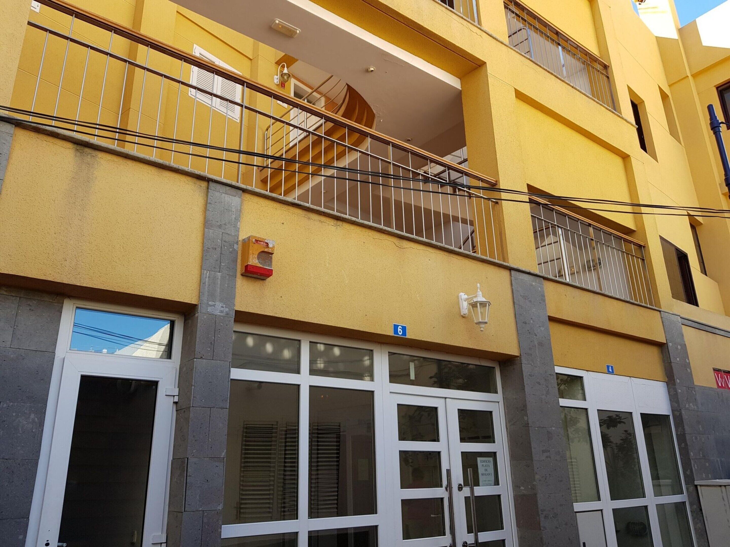 Un edificio amarillo con una escalera que conduce a un balcón.