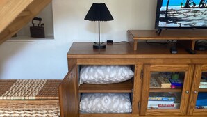 Ein Holzschrank mit zwei Schubladen, eine Lampe und ein Fernseher auf einem Holzboden.