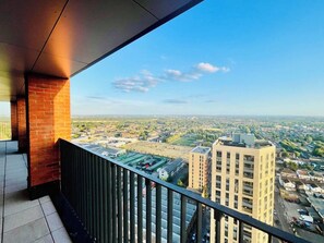 A balcony with a view of a cityscape, including buildings and a clear sky. - Healum Retreat - 3BR Apartment, Southall (Southall)