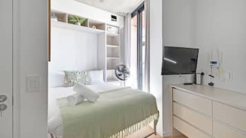 Una camera da letto moderna con un letto, una TV e una libreria a muro.