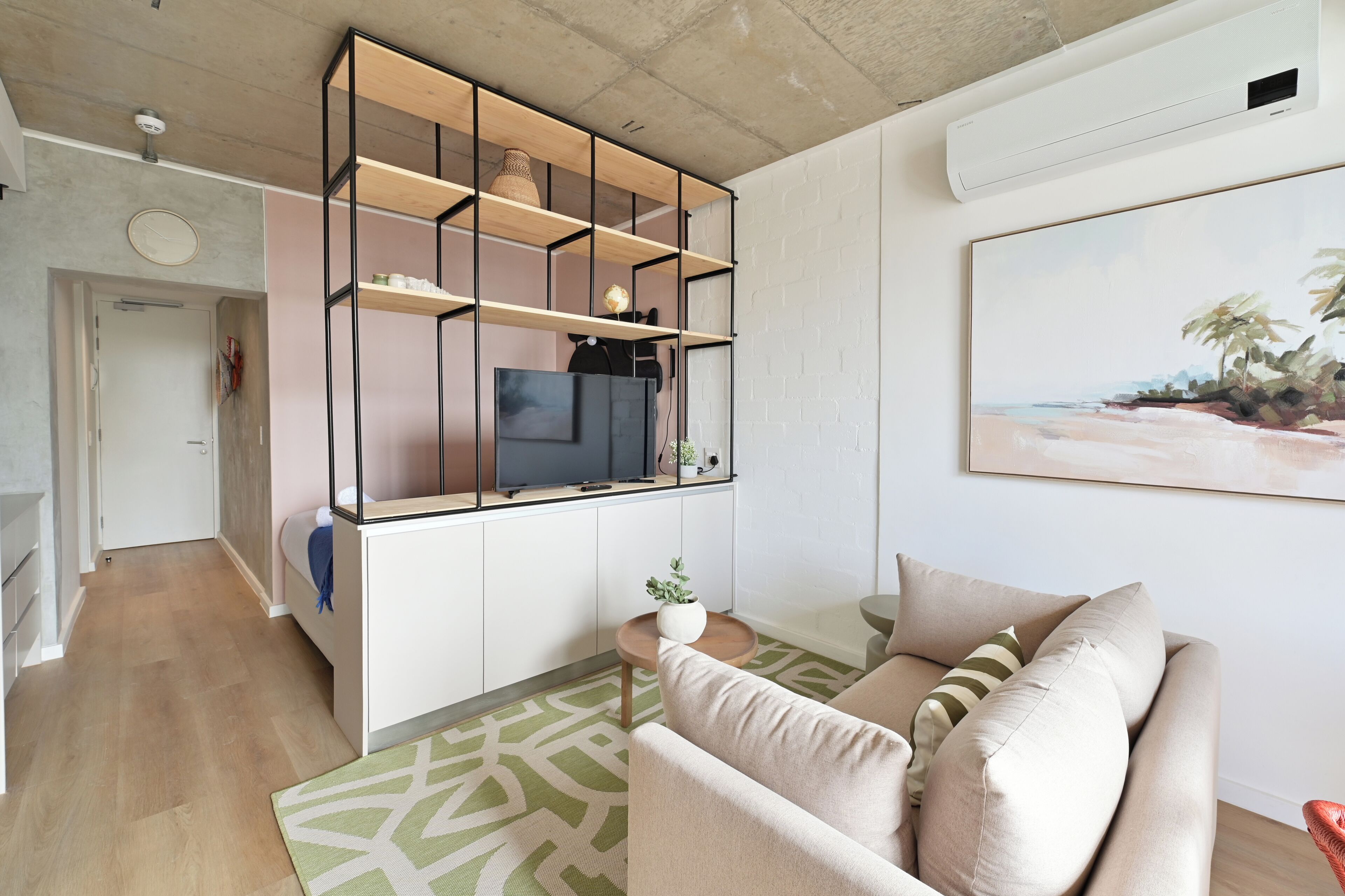 En moderne stue med sofa, sofabord og indbygget tv-reol.