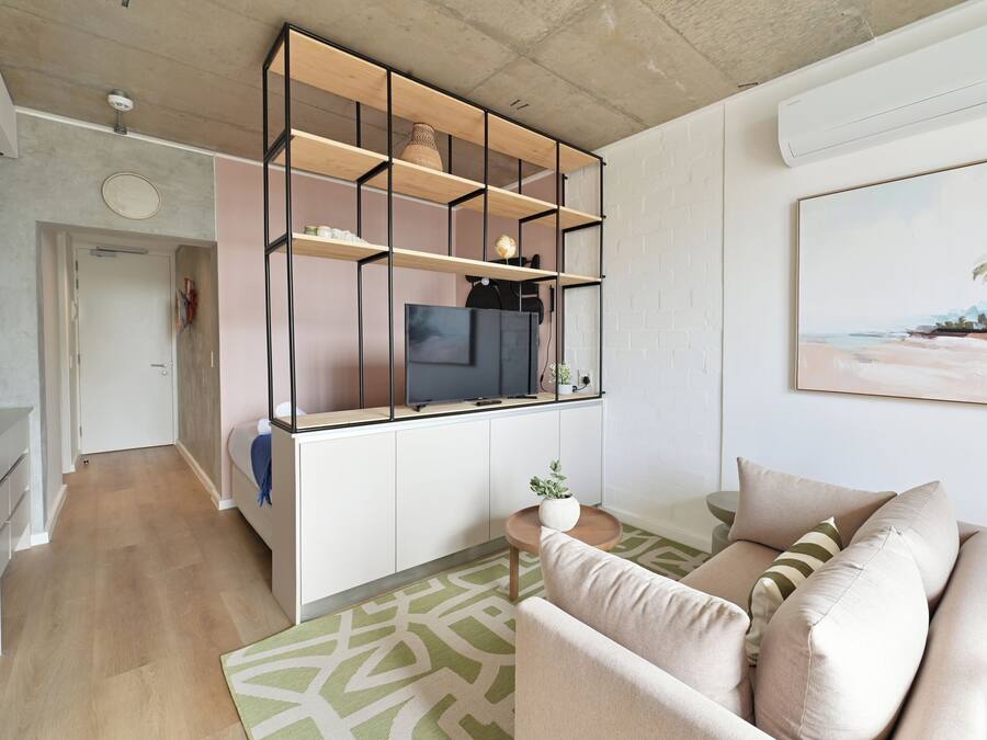Een moderne woonkamer met een bank, een salontafel en een ingebouwde tv-kast.