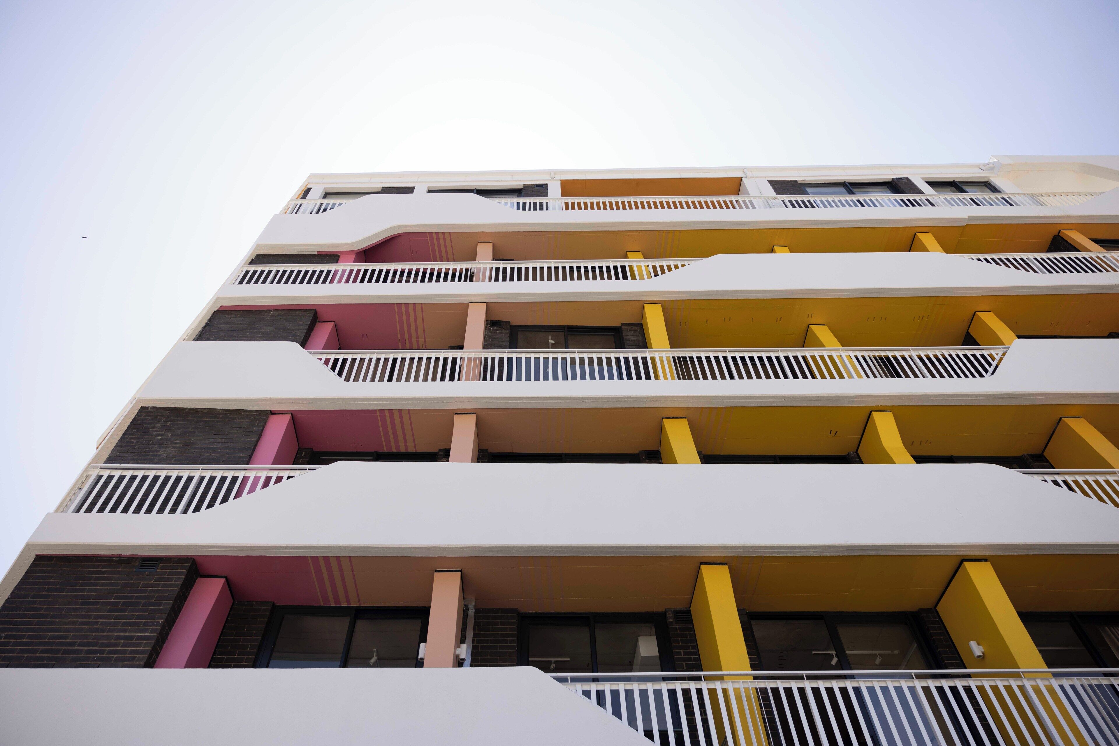 Un edificio a più piani con balconi e tetto piano.