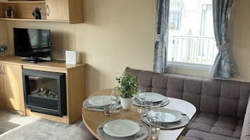 Cozy living space with a dining area, seating area, and television, perfect for relaxing and enjoying meals.