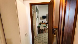 A narrow hallway with patterned flooring leading to a dining area with a table and chairs. - A few steps from beaches and center! (Otranto)