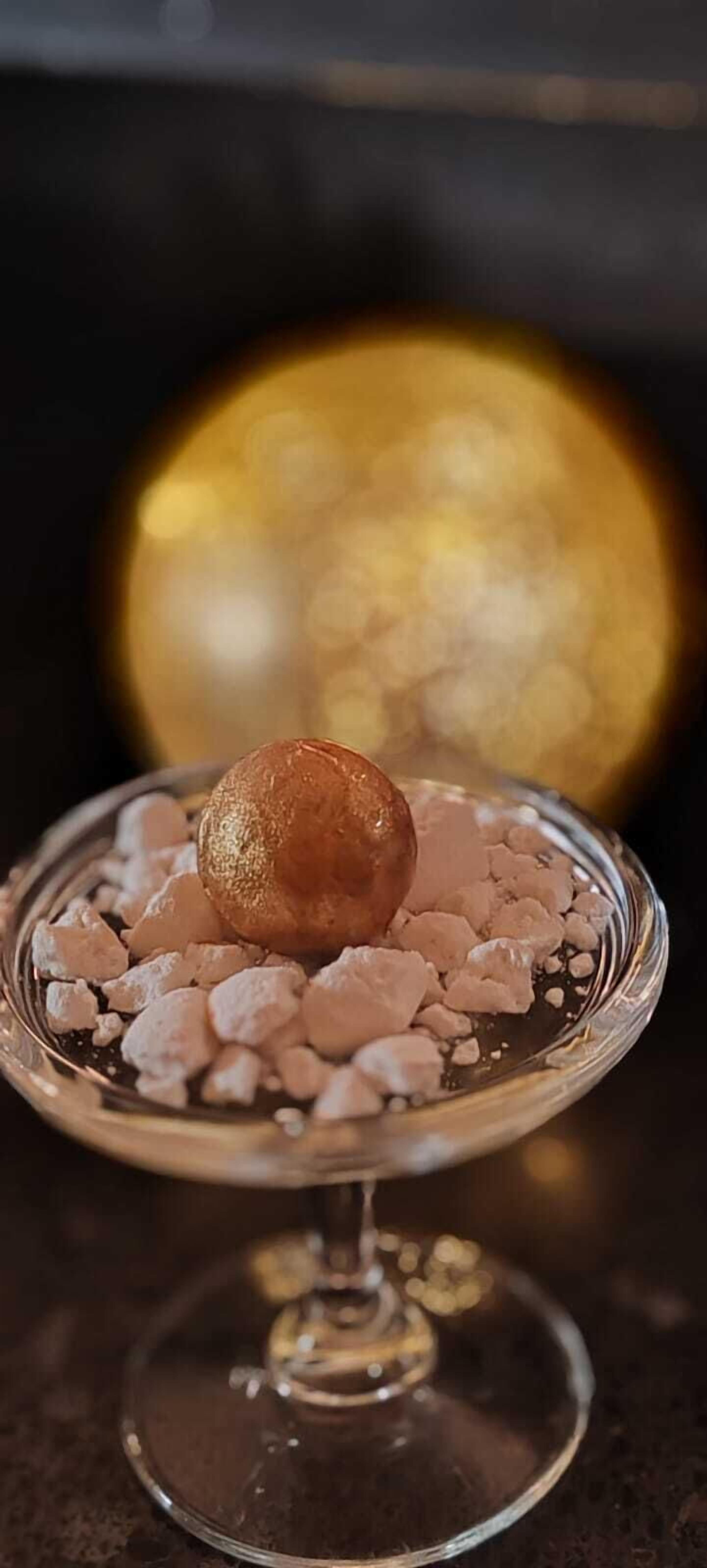 Un dessert présenté sur une assiette en verre, avec un arrière-plan flou.
