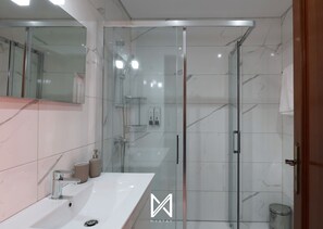 Habitación doble | Baño | Ducha, secador de pelo, toallas y jabón
