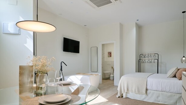 A modern bedroom with a bed, bedside table, and a TV mounted on the wall. - Romantic Apartment N2 Oceanografico Virkin Suites (València)