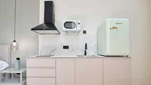 A modern kitchen with a white countertop, a built-in microwave, a black range hood, and a light green refrigerator. - Romantic Apartment N2 Oceanografico Virkin Suites (València)