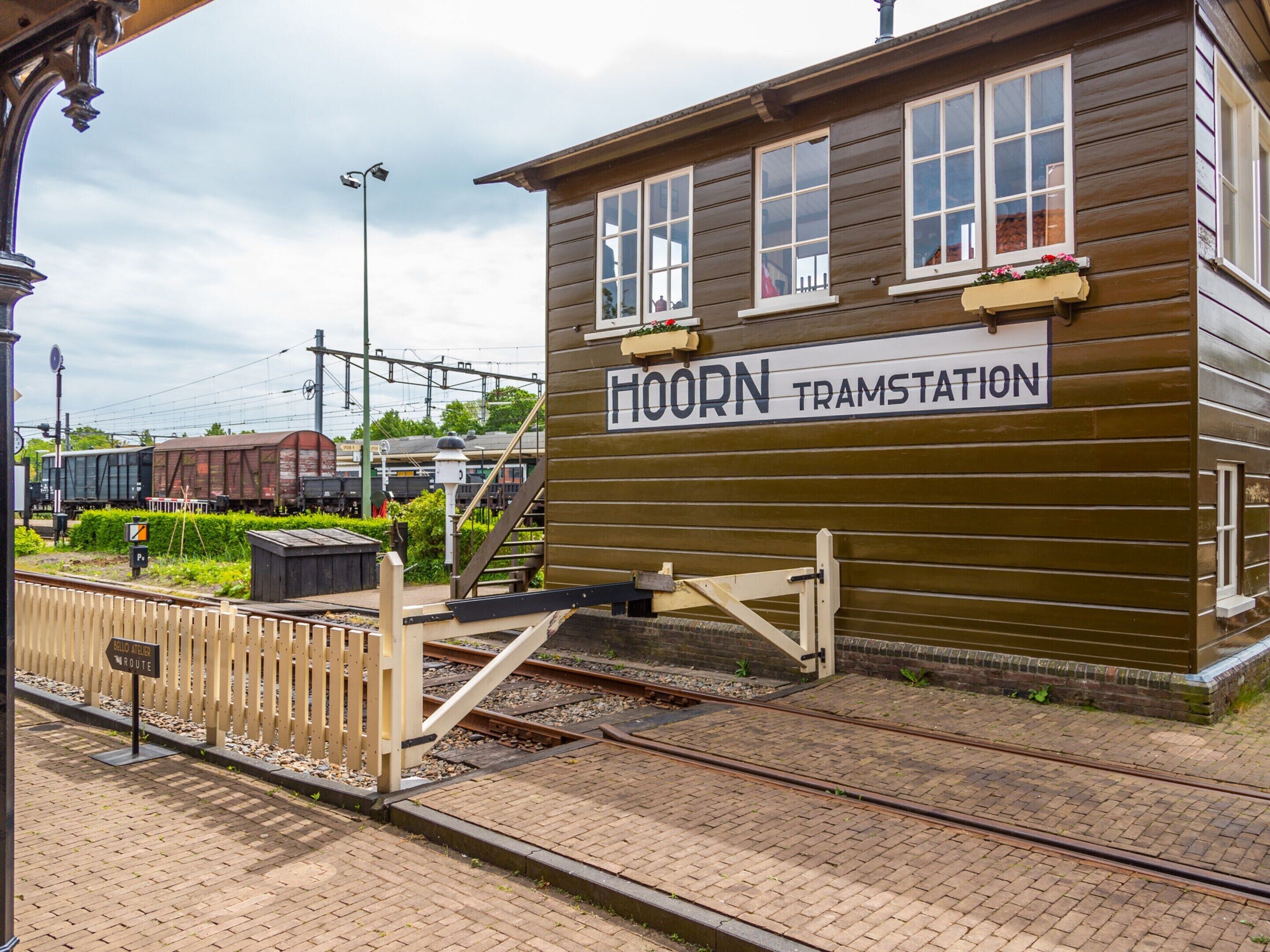 A wooden building labeled "HOORN TRAMSTATION" with a sign indicating a railway route.
