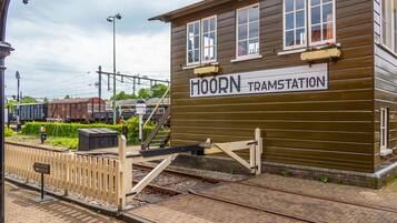 A wooden building labeled "HOORN TRAMSTATION" with a sign indicating a railway route.