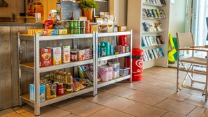 Una tienda de conveniencia bien surtida con estantes llenos de aperitivos, bebidas y artículos para el hogar.