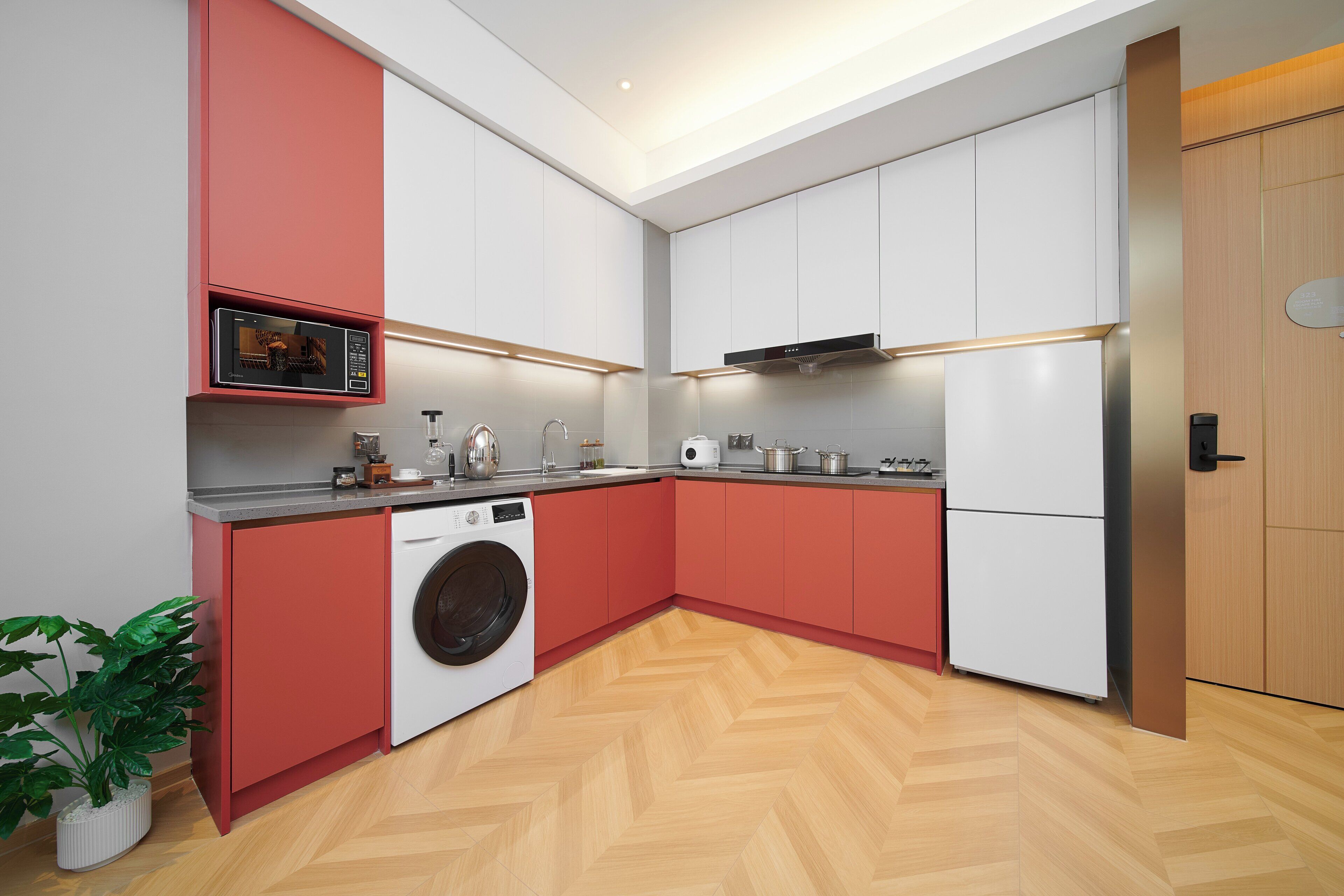Una cocina moderna con lavadora, microondas y horno empotrado.