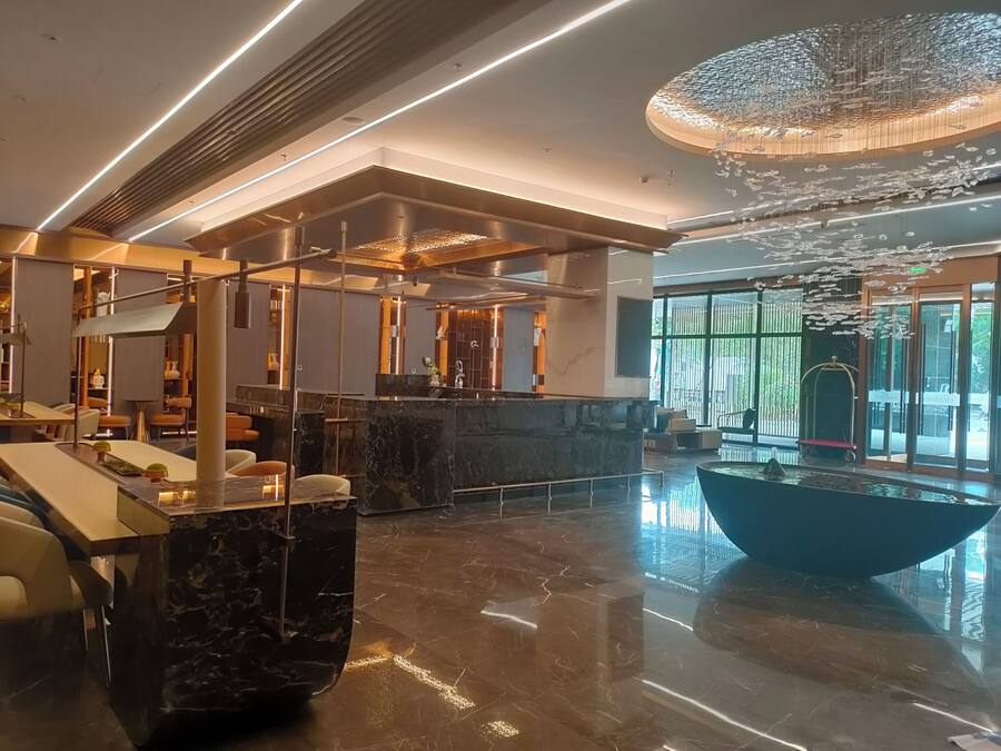 Eine moderne Lobby mit einer Marmorrezeption, Sitzbereichen und einer großen Kandelaber.
