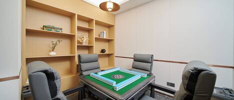 A conference room with a table, chairs, and shelves with various items.