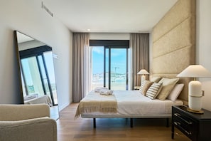 Habitación de hotel con cama, lámparas de noche, un espejo grande, vistas de la ciudad y una ventana con cortinas.