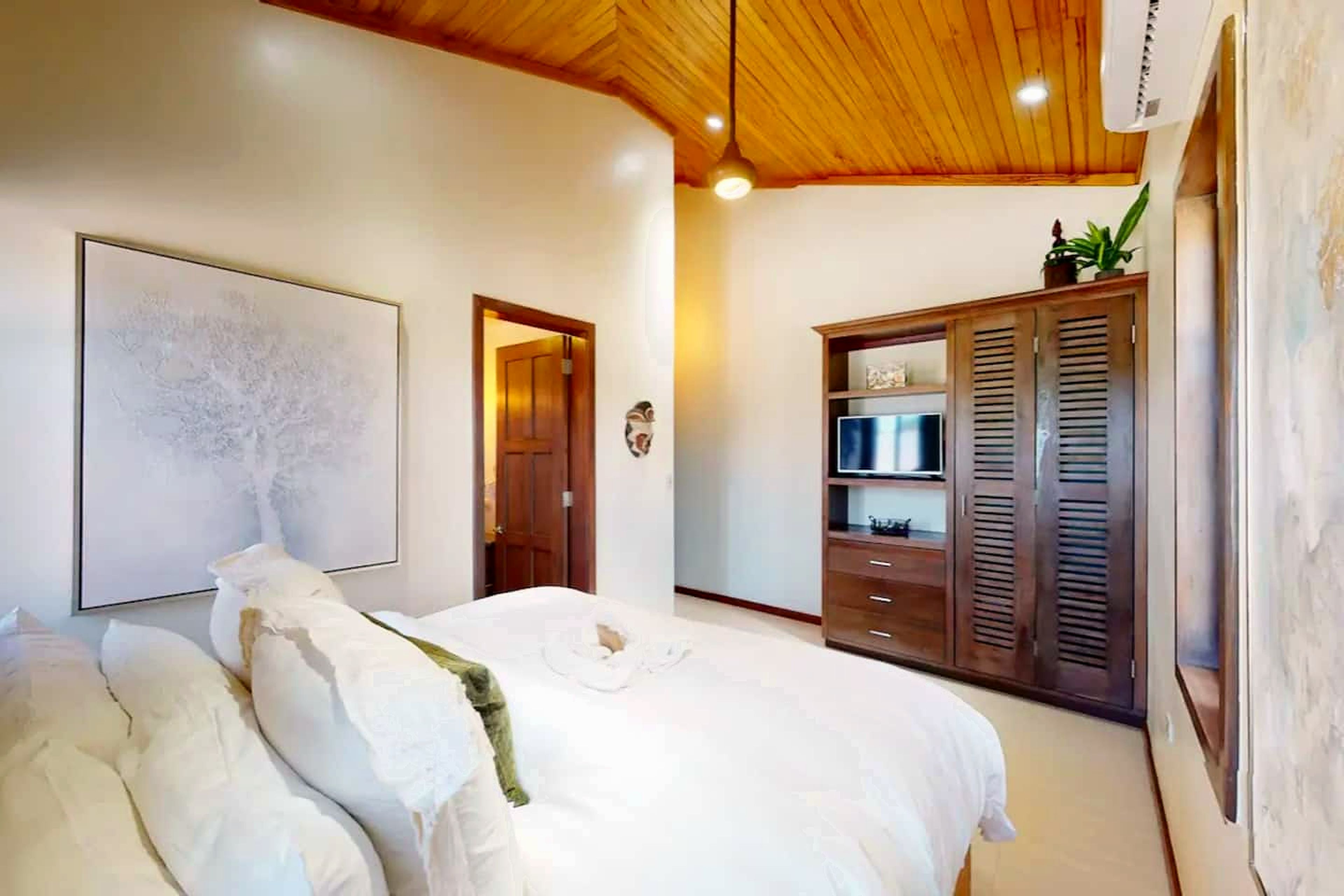 A bedroom with a bed, a wardrobe, and a ceiling light.