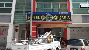 A building with a sign for "HOTEL PUTERI MIQAILA" and a fire truck parked in front. - Hotel O Puteri Miqaila (Bota)