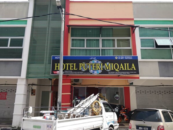 A building with a sign for "HOTEL PUTERI MIQAILA" and a fire truck parked in front. - Hotel O Puteri Miqaila (Bota)