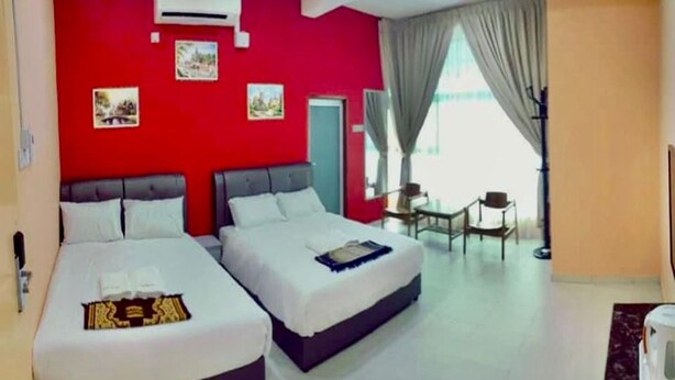 A hotel room with two beds, a red accent wall, an air conditioning unit, and a view of the outdoors. - Hotel O Puteri Miqaila (Bota)