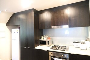 Casa de ciudad Premium, 4 habitaciones, vista al patio | Cocina privada | Refrigerador con congelador, microondas, horno y parrilla de estufa 