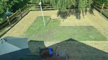 A fenced outdoor area with a bench and a trash bin.