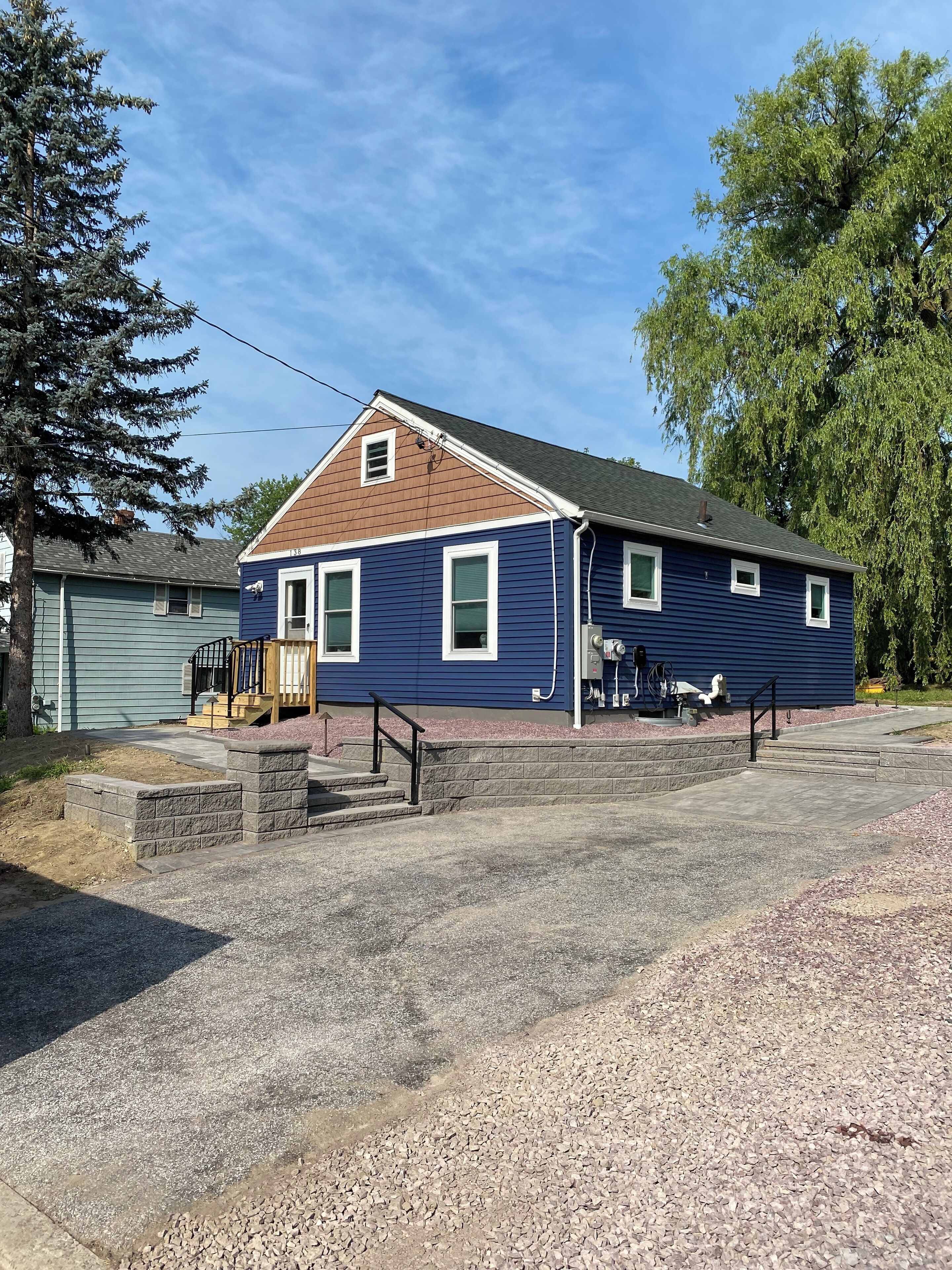 A two-story house with a blue exterior and a brown roof.