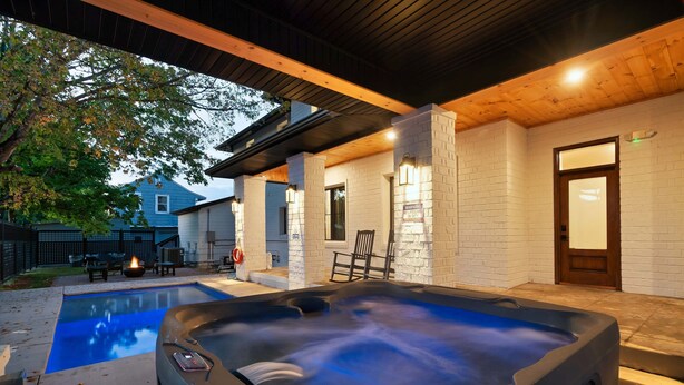 A hot tub with a wooden deck, a pool, and a brick wall with a door. - Downtown Sevierville ・ Sleeps 30 ・Pool & Hot Tub (Sevierville)