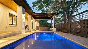 A swimming pool with a covered patio area, a brick wall, and a gated fence. - Downtown Sevierville ・ Sleeps 30 ・Pool & Hot Tub (Sevierville)