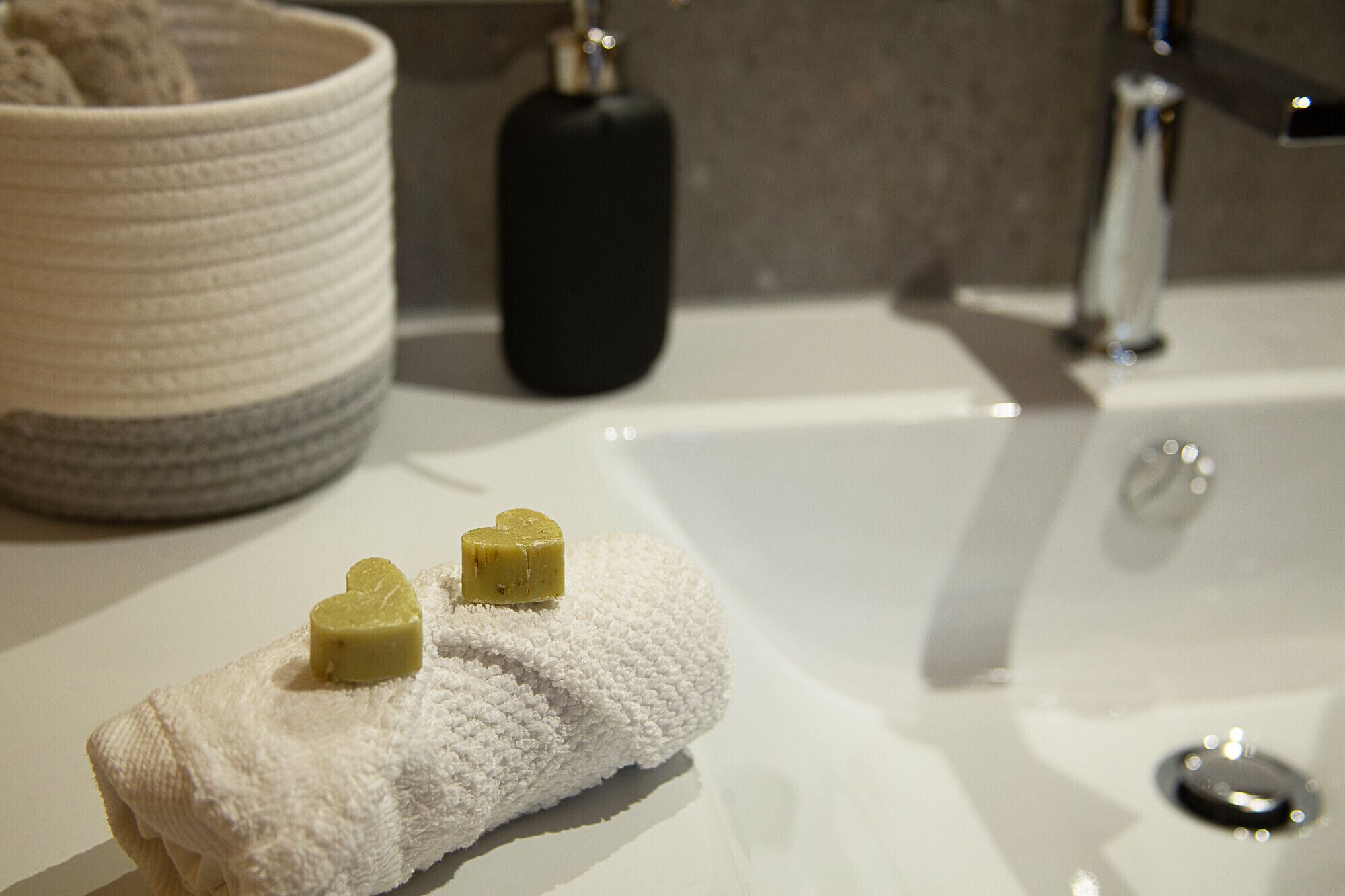 A bathroom sink with a white towel and two soap bars on it.