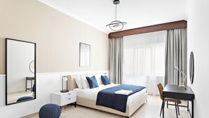 A modern bedroom with a bed, bedside tables, a desk, and a chair. - Silkhaus Art Residence Sheikh Zayed Road (Dubai)