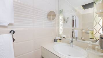 Un bagno moderno con uno specchio grande, un lavandino e un porta asciugamani.