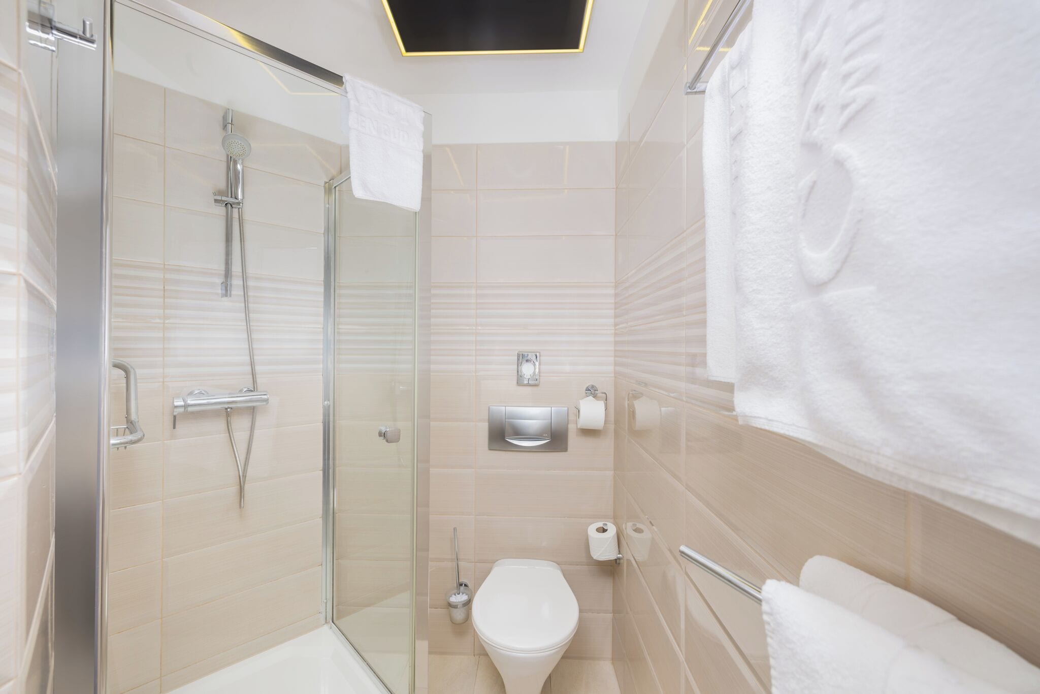 Un bagno moderno con box doccia in vetro, un water e un appendi asciugamani.