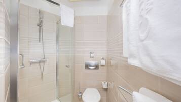 Un bagno moderno con box doccia in vetro, un water e un appendi asciugamani.