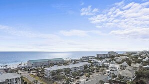 A coastal hotel area with beachfront properties, a large hotel building, and a clear view of the ocean.