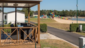 A covered outdoor seating area with a view of a playground and beach. - Breebos Chalet Near Antwerp Camp (Rijkevorsel)