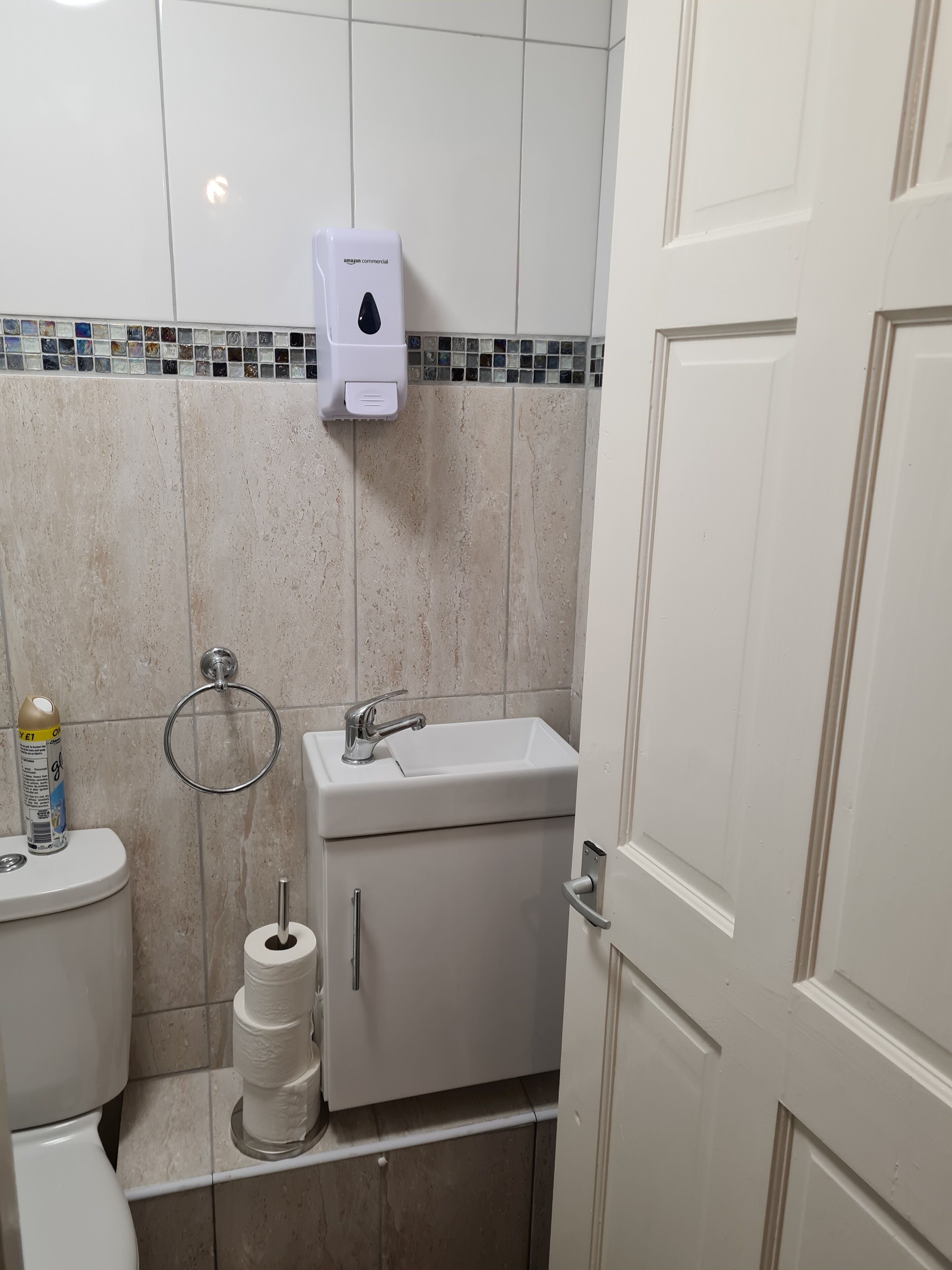 A small bathroom with a toilet, sink, and hand dryer.