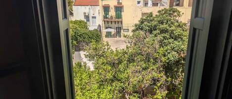 A view from a window overlooking a residential area with buildings and greenery.