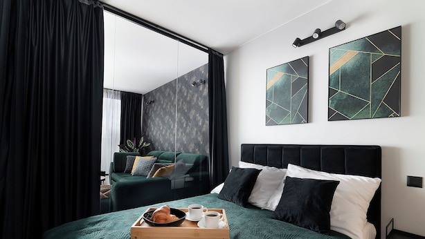 A modern hotel room with a large bed, a bedside table, a tray with breakfast items, and a large window with curtains. - EASY RENT Apartments - Brilliant (Lublin)
