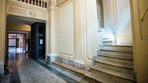 A grand staircase with marble steps and ornate wall paneling. - Imperial House  (Roma)