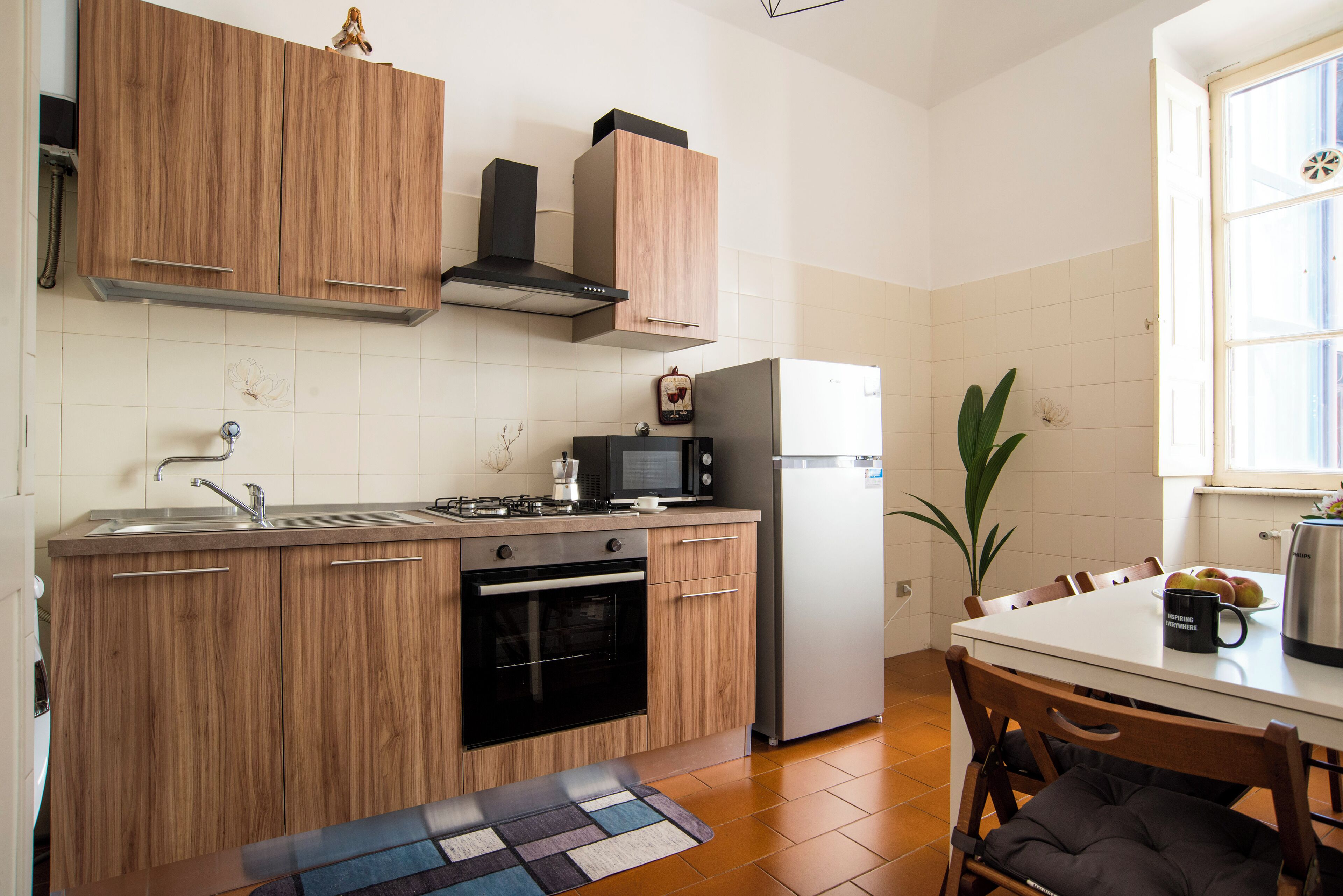 Una cocina moderna con armarios de madera, estufa, microondas y refrigerador.