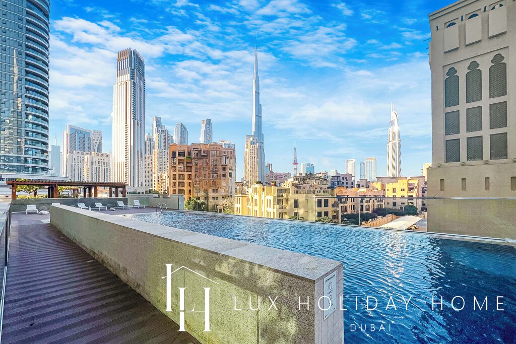 A rooftop pool with a view of Dubai skyline, including the Burj Khalifa.
