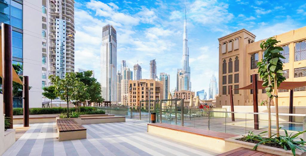 A rooftop terrace with a view of Dubai's skyline, including the Burj Khalifa.