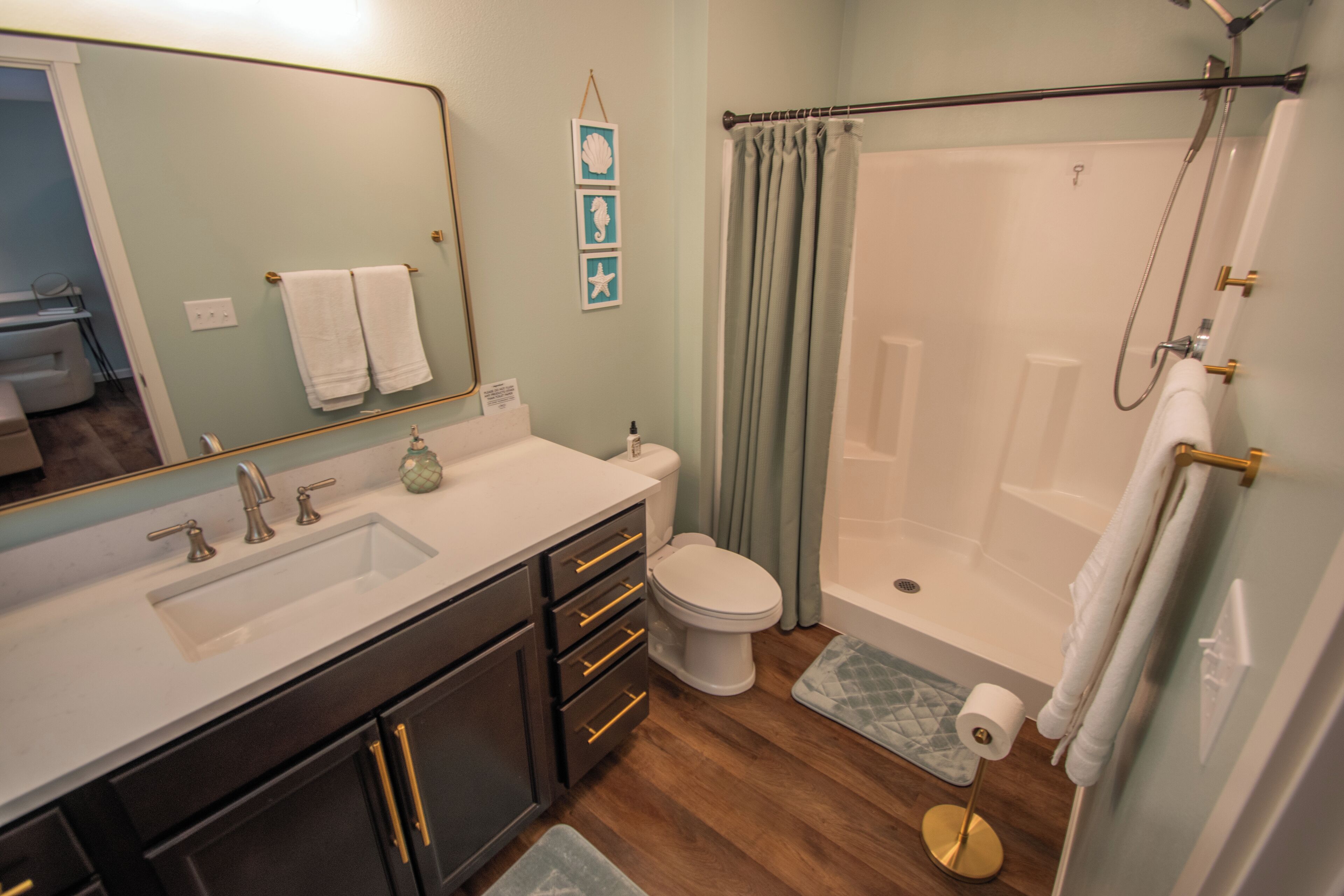 A bathroom with a sink, toilet, and shower.