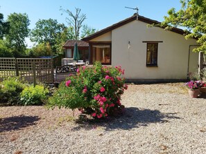 A house with a gravel driveway, a wooden fence, and a garden with pink flowers. - Peaceful and Stylish Cottage Near Taunton Somerset (Taunton)