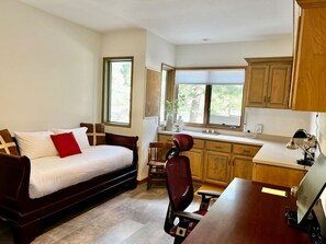 A compact living space with a sofa, a dining table, and a kitchen area. - The Alpine Vista | Pets | Couples | Golf | Nakoma (Portola)